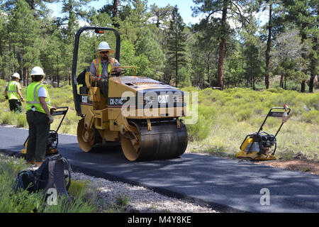 Un lavoratore leviga oltre l'asfalto su un lastricatore. Tra il 10 agosto al 10 settembre 2016 la Greenway sentiero tra il Teatro IMAX area di parcheggio in Tusayan e centro strada nel Parco Nazionale del Grand Canyon verrà chiusa mentre il Grand Canyon Trail dell equipaggio installa asfalto. Il tratto del sentiero a nord della strada del centro non saranno interessati. Mentre il sentiero chiusura è in effetti, i ciclisti e gli escursionisti possono cavalcare la navetta Tusayan (percorso viola) che è dotato di supporto per bicicletta rack. La navetta collega Tusayan con il bordo meridionale Visitor Center, a 20 minuti in ogni modo. L intento di questo proje Foto Stock