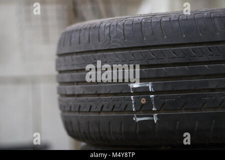 Pneumatici sul pavimento sono danneggiati da colpire chiodi o oggetti appuntiti, con conseguenti perdite di gomma e non può essere eseguito su strada. Foto Stock