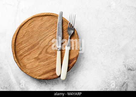 Argenteria vintage e piatto in legno su cemento grigio Sfondo. Ristorante impostazione tabella, design mock up e alimentare il concetto di pubblicità Foto Stock