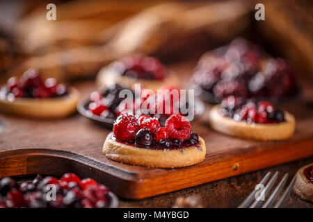 Shortcake torte, mini tortine con fress frutta sul tavolo di legno Foto Stock