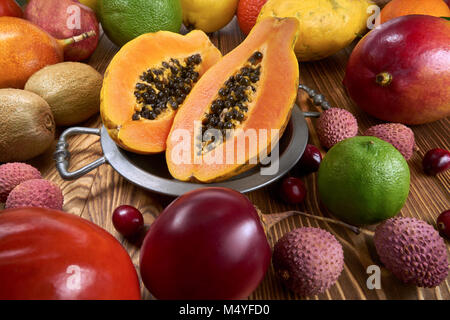 Papaya frutto su una ciotola di stagno, intorno un sacco di frutti di una specie differente Foto Stock