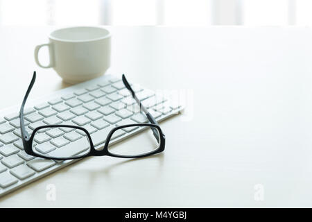 Close up di bicchieri e computer business sul posto di lavoro posto di lavoro in ufficio Foto Stock