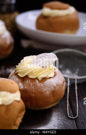 Semla svedese bun crema scuro su sfondo di legno Foto Stock