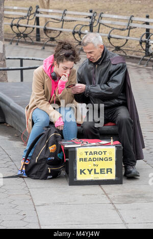 Kyler psichica non una carta dei tarocchi lettura per un interessato giovane lady in Washingotn Square Park a Manhattan, New York City. Foto Stock