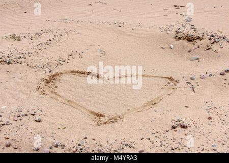 Cuore disegnato sulla sabbia su una spiaggia. Foto Stock