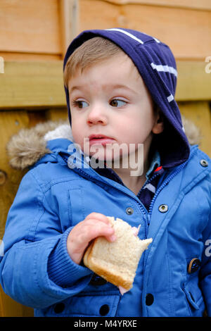 Il Toddler fuori a mangiare un panino Foto Stock