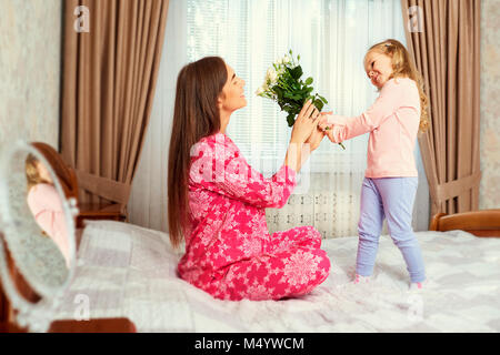 La figlia si congratula con la madre con fiori sulle vacanze Foto Stock