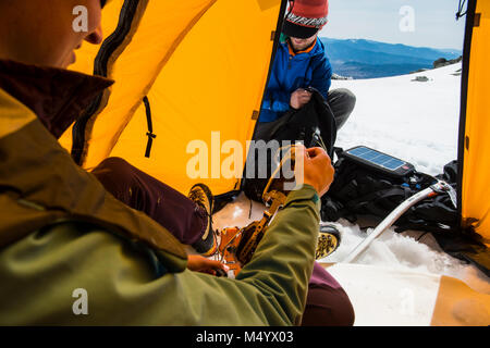 L uomo e la donna l'impostazione di campeggio in inverno nelle White Mountains, New Hampshire, STATI UNITI D'AMERICA Foto Stock