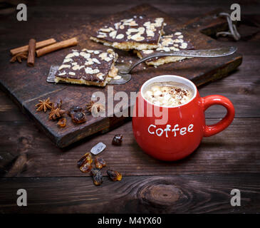 Rosso tazza ceramica con caffè e marshmallows su un di legno marrone, sfondo vista superiore Foto Stock