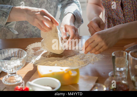 Le donne per la cottura della pizza a casa. Due donne irriconoscibili gli impasti Foto Stock