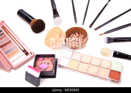 Raccolta di vari costituiscono accessori. Spazzola per il trucco e prodotti cosmetici. Una collezione di cosmetici prodotti di bellezza disposte intorno a una rosa make up. Foto Stock