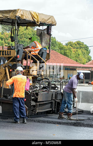 PENANG, MALAYSIA, NOV 10 2017, l'asfalto macchina mette una nuova superficie - strato sulla strada. Una ripavimentazione la costruzione della strada. Foto Stock