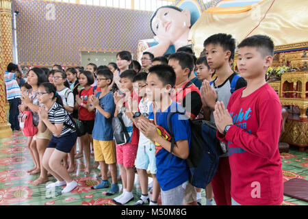 MALAYSIA, Penang, NOV 11 2017, Buddha reclinato Wat Chaiyamangalaram. A scuola di viaggio su un monastero buddista. Bambini pregare prima del Buddha sdraiato. Foto Stock