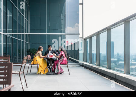 Tre Indian business persone che parlano durante la pausa di lavoro Foto Stock