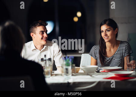 Gruppo di amici avente una cena in un ristorante.Double Data.attraente persone night out,di pranzare in un hotel alla moda.le persone che visitano un nuovo luogo aperto.B Foto Stock