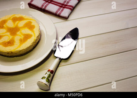 Di recente fatto di limone Torta di formaggio collocato sul tavolo di cucina pronti a servire Foto Stock