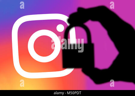 LONDON, Regno Unito - 5 febbraio 2018: Instagram concetto della sicurezza. Silhouette di una mano che tiene un lucchetto di fronte al logo Instagram Foto Stock