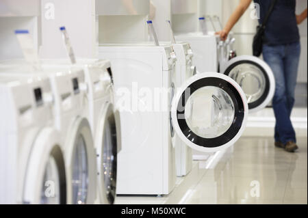 Le macchine di lavaggio in appliance store e acquirente sfocati Foto Stock