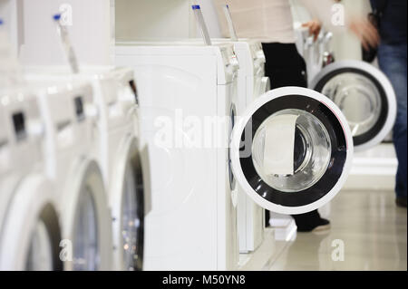 Le macchine di lavaggio in appliance store e acquirente sfocati Foto Stock