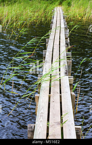 Passerella in legno sopra l'acqua alla spiaggia Foto Stock