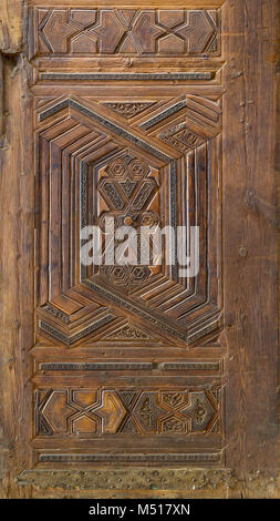 Geometrici e floreali motivi incisi di stile Mamluk ornati in legno battente di porta di madrasa di Sultan Nagm al Din Ayyub al Cairo, Egitto Foto Stock