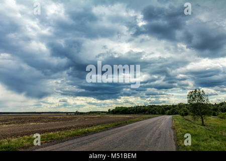 Misterioso nuvole nel cielo su una strada di campagna Foto Stock