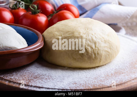 Rendendo gourmet pizza con i germogli topping. Materie impasto per pizza con ingredienti, close-up Foto Stock