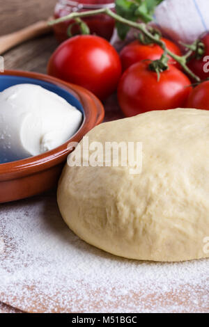 Rendendo gourmet pizza con i germogli topping. Materie impasto per pizza con ingredienti, close-up Foto Stock