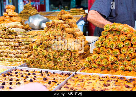 Varietà di dolci sulla strada araba di stallo del mercato. I dolci orientali in un ampio intervallo, baklava, delizie turche con mandorla, anacardi e pistacchi di Bronte Foto Stock