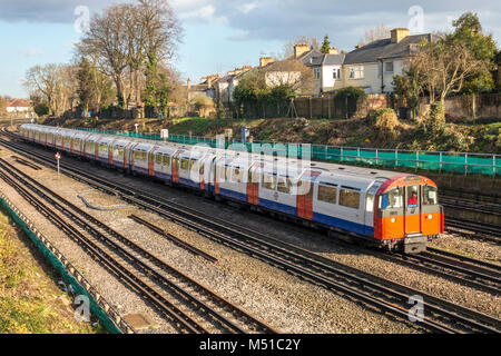 La metropolitana di Londra (LUL) tubo treno viaggia overground avvicinandosi a sud della stazione di Ealing, London W5, Inghilterra, Regno Unito. Foto Stock