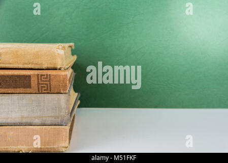 Pila di vecchio libro vintage su sfondo verde Foto Stock