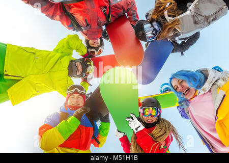 Gruppo di amici felice sorge in cerchio con gli snowboard Foto Stock