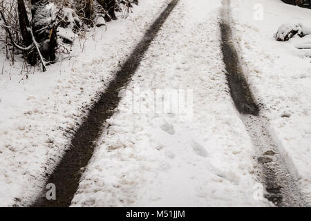 background texture of dirt road covered with snow and tire tracks Foto Stock