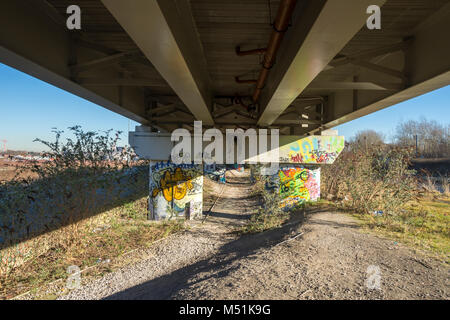 Graffiti sotto il tram Metrolink viadotto, tra il Manchester Ship Canal e la Bridgewater Canal, Pomona Docks, Manchester, Inghilterra, Regno Unito Foto Stock