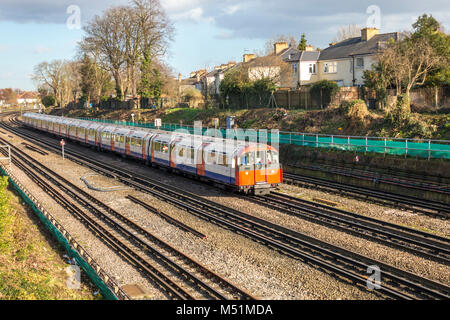 La metropolitana di Londra (LUL) tubo treno viaggia overground avvicinandosi a sud della stazione di Ealing, London W5, Inghilterra, Regno Unito. Foto Stock