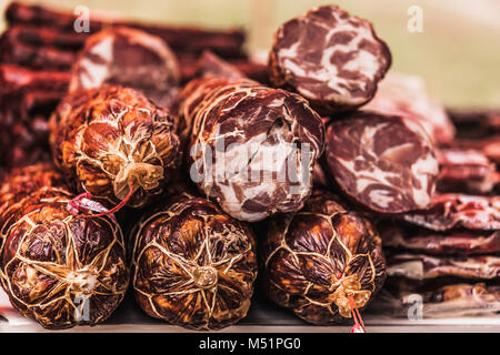 Deliziosi pezzi di carne affumicata esposte per la vendita nel mercato. Messa a fuoco selettiva e piccole profondità di campo Foto Stock