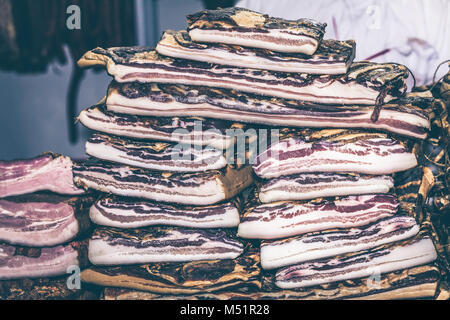 In casa la pancetta sulla tabella esposta per la vendita. Messa a fuoco selettiva e piccole profondità di campo Foto Stock