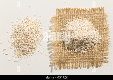 Avena sativa è il nome scientifico di avena Grani di cereale. Noto anche come Aveia o avena. Close up di grani sparsi su tavolo bianco. Foto Stock
