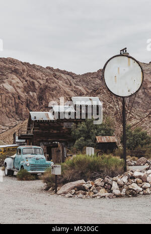 Vintage vecchio arrugginito carrello auto abbandonate il abbandonata la stazione di gas. Foto Stock