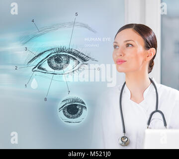 Donne medico lavora con interfaccia virtuale esaminando occhio umano Foto Stock