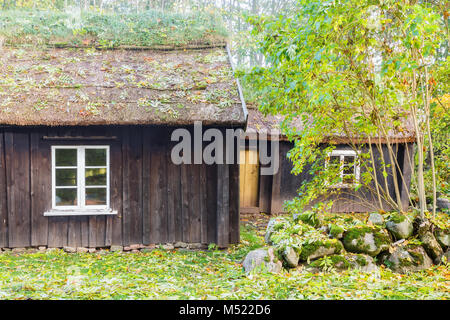 Vecchio cottage di legno con tetto di paglia Foto Stock