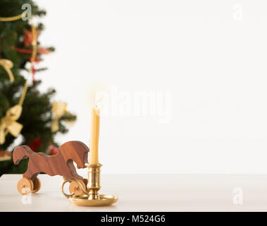 Vintage Cavallo di legno su Santa della tavola di lavoro, albero di Natale sullo sfondo Foto Stock