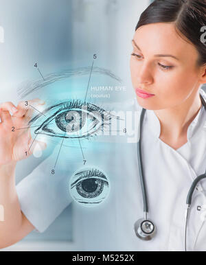 Donne medico lavora con interfaccia virtuale esaminando occhio umano Foto Stock
