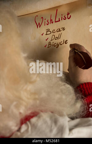 Close-up di Natale wishlist lettera a Babbo Natale le mani Foto Stock