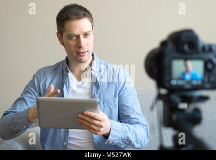 Uomo bello fare video blog sui tablet pc. Foto Stock