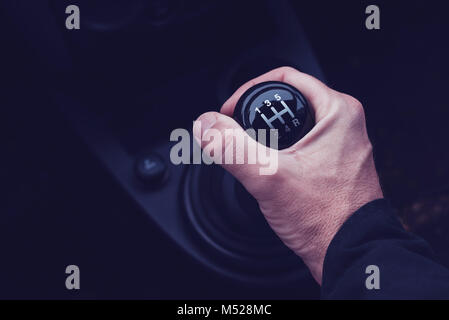 Maschio lato cambio marcia in auto mentre si guida il veicolo a motore, ultra violet tonica ombre Foto Stock