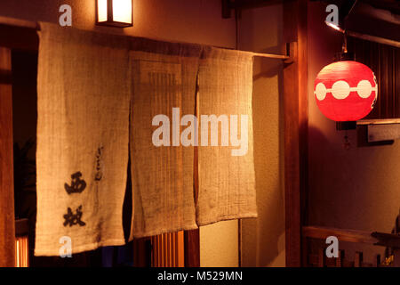 Nishizaka tradizionale ristorante giapponese di Kyoto, Gion, porta di ingresso con un Noren tenda ed una lanterna rossa di notte. Hanamikoji Dori Street in gio Foto Stock