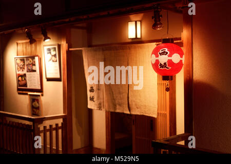 Gion Nishizaka, tradizionale ristorante giapponese porta di ingresso con un Noren tenda illuminata da una lanterna di notte. Hanamikoji Dori Street in Gion distri Foto Stock