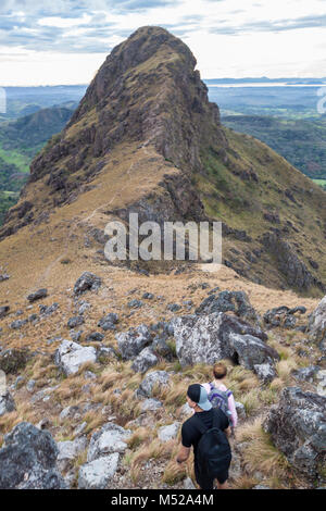 Gli escursionisti quasi alla sommità del Cerro Pelado in Costa Rica, la mattina presto girato con il terreno roccioso e erba essiccata al vento. Foto Stock