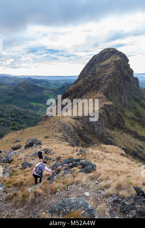 Gli escursionisti quasi alla sommità del Cerro Pelado in Costa Rica, la mattina presto girato con il terreno roccioso e erba essiccata al vento. Foto Stock